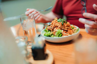 A plate of food on a dining table with a person visible