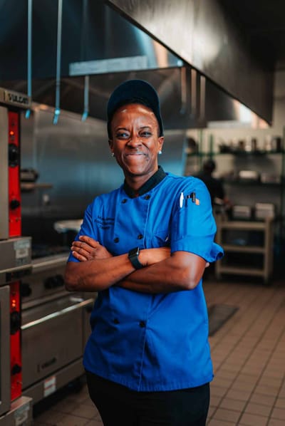 A chef smiling in a kitchen setting