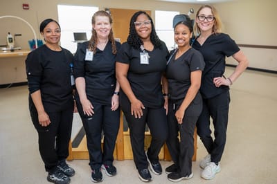 Staff members smiling together in a common area