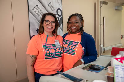 Two staff members smiling at a reception desk