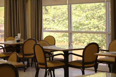 Dining area with empty tables and chairs facing a window