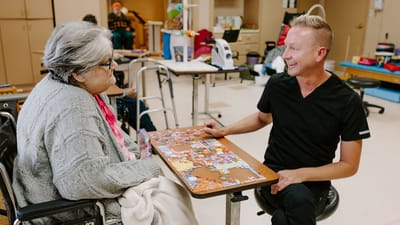 Staff engaging with a resident during a puzzle activity