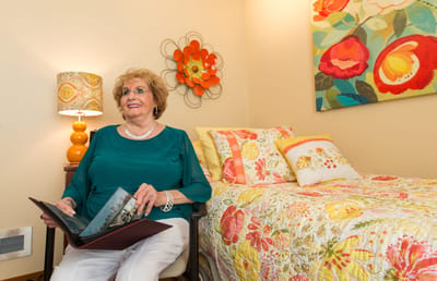 Resident enjoying a photo album in a vibrant room