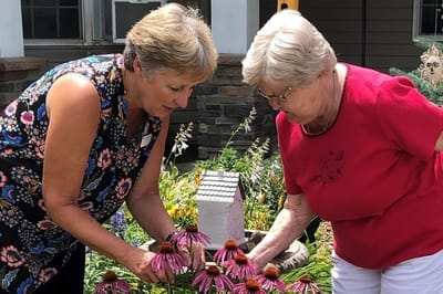 Staff member and resident gardening together
