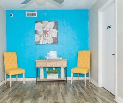 Bright interior space with yellow chairs and a welcome sign