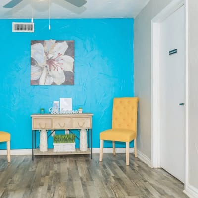 Bright interior waiting area with yellow chairs and a blue wall