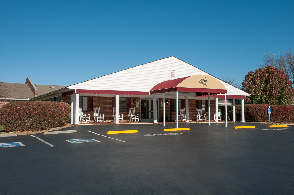 Exterior view of the facility entrance with rocking chairs