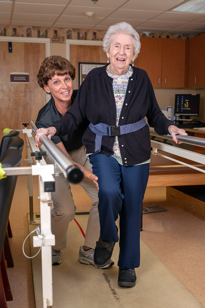 Resident participating in physical therapy with staff support
