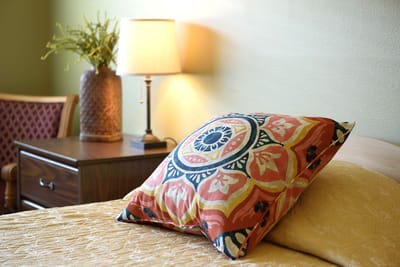 Cozy bedroom with decorative pillow and lamp