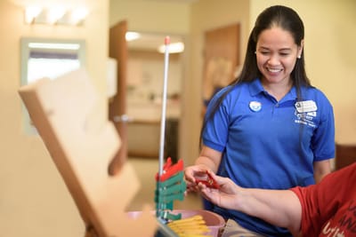 Staff assisting a resident with an activity in the facility