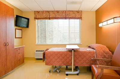 Interior view of a resident room with a bed and TV