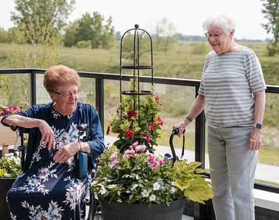 Two residents enjoying flowers on a balcony