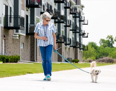 A resident walking a dog in front of the building