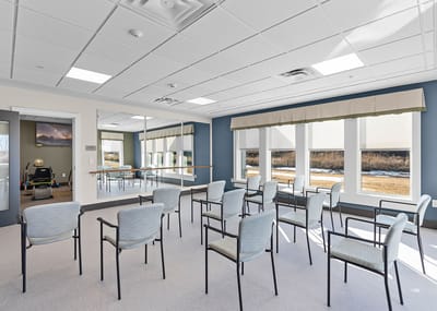 Bright activity room with empty chairs and windows