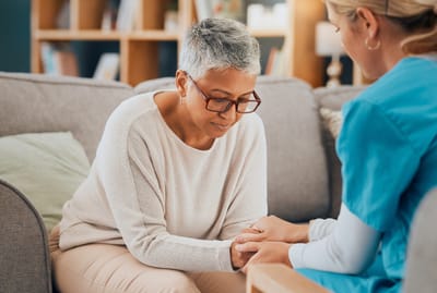 A resident and staff member sharing a moment in the lounge