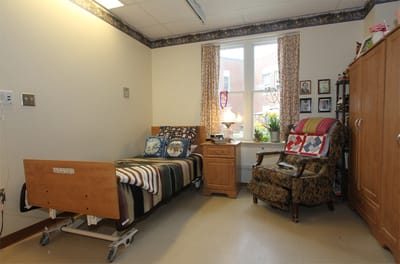 Private resident room with bed and chair