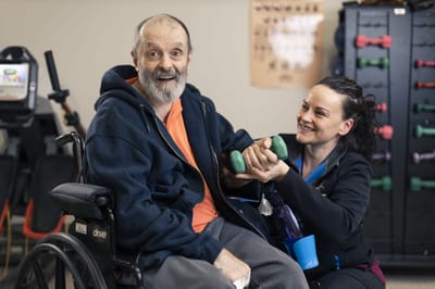 A resident exercising with staff assistance