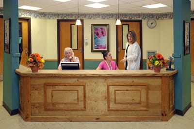 Reception area with staff assisting a resident.