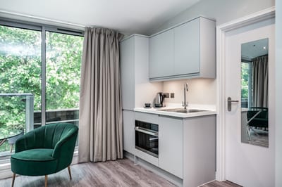 Modern kitchenette with green chair and natural light
