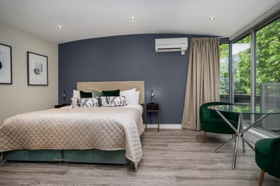 A well-furnished private room with a bed and seating area.