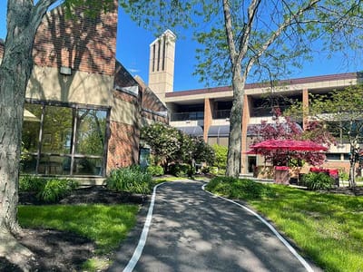 Pathway leading to a senior living facility with landscaping.