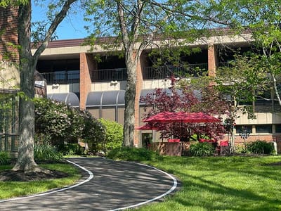 Exterior view of the facility with gardens and seating area