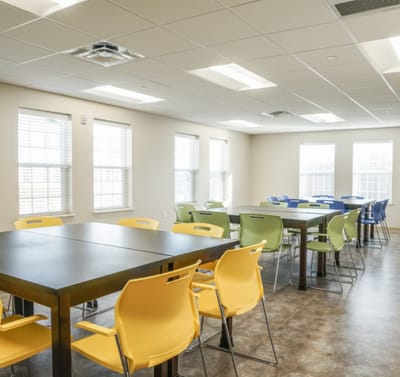 Bright activity room with colorful chairs and tables