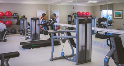 Interior gym space with exercise equipment and residents