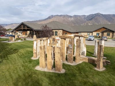 Exterior view of Stonehenge of Ogden with landscaping and mountains