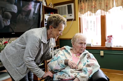 Care staff interacting with a resident in a cozy indoor setting
