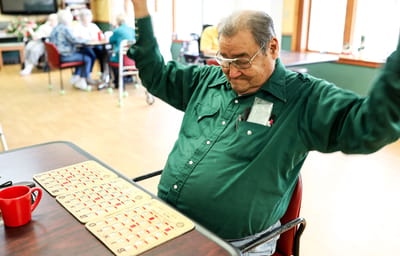 Resident celebrating a win in a bingo game in a common area