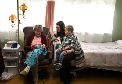 A resident, family member, and child enjoying time together in a cozy room