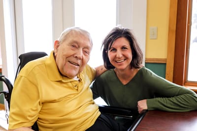 Resident and staff member smiling together