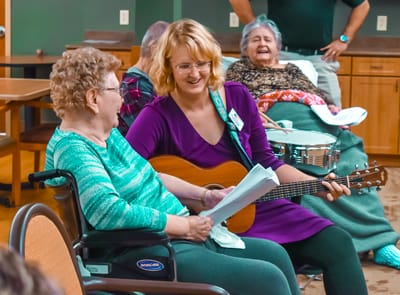Resident enjoying music therapy session with staff