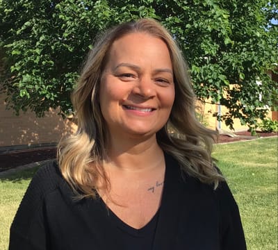 Staff member smiling in an outdoor setting