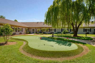 Well-maintained outdoor putting green with seating area