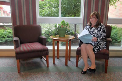 A resident reading in a sitting area with plants