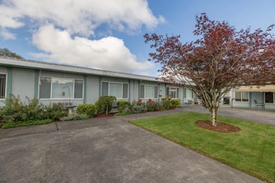 Exterior view of Woodland Assisted Living facility with landscaped area
