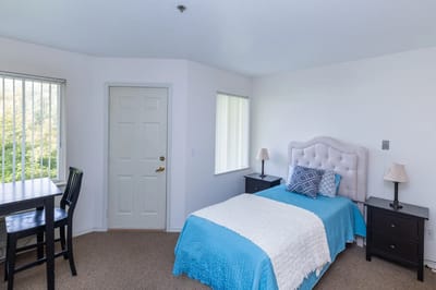 Bright, tidy resident room with a bed and table