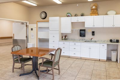 Bright common area with a table and kitchenette
