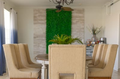 Dining area with a large wooden table and beige chairs