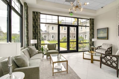 Bright common area with seating and garden view