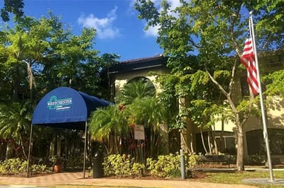 Entrance of Westchester of Sunrise with landscaping and flag