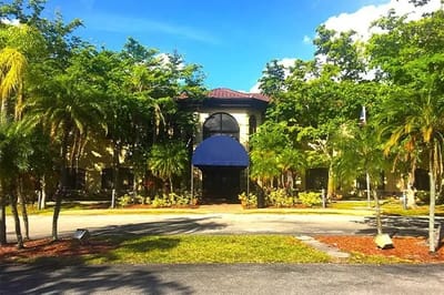 Front view of the Westchester of Sunrise building surrounded by greenery