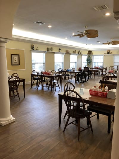 Dining room setup with tables and chairs for residents