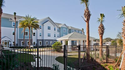 Exterior view of Trinity Springs facility with palm trees