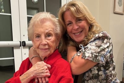 Resident and staff member posing together in a common area