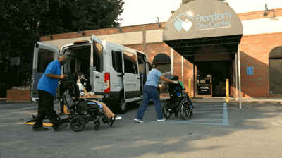 Staff assisting residents at the facility entrance