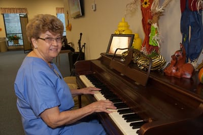 A resident playing the piano in a decorated room