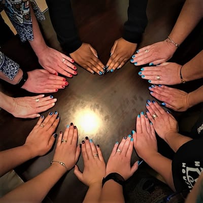Residents showcasing their colorful manicures around a table